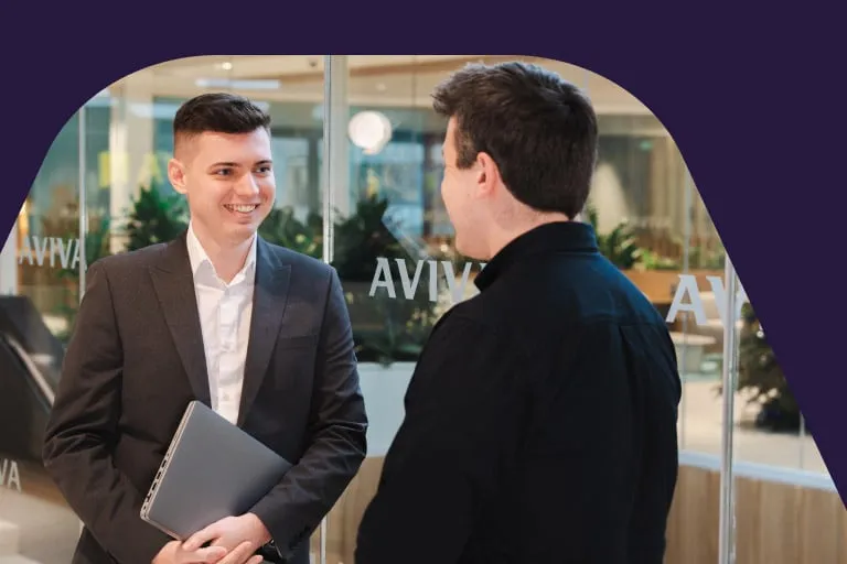 Two Smartly Dressed Young Men Talking in Modern Office