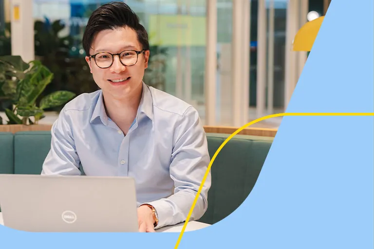 A professional man in glasses is working at a laptop in an Aviva breakout space