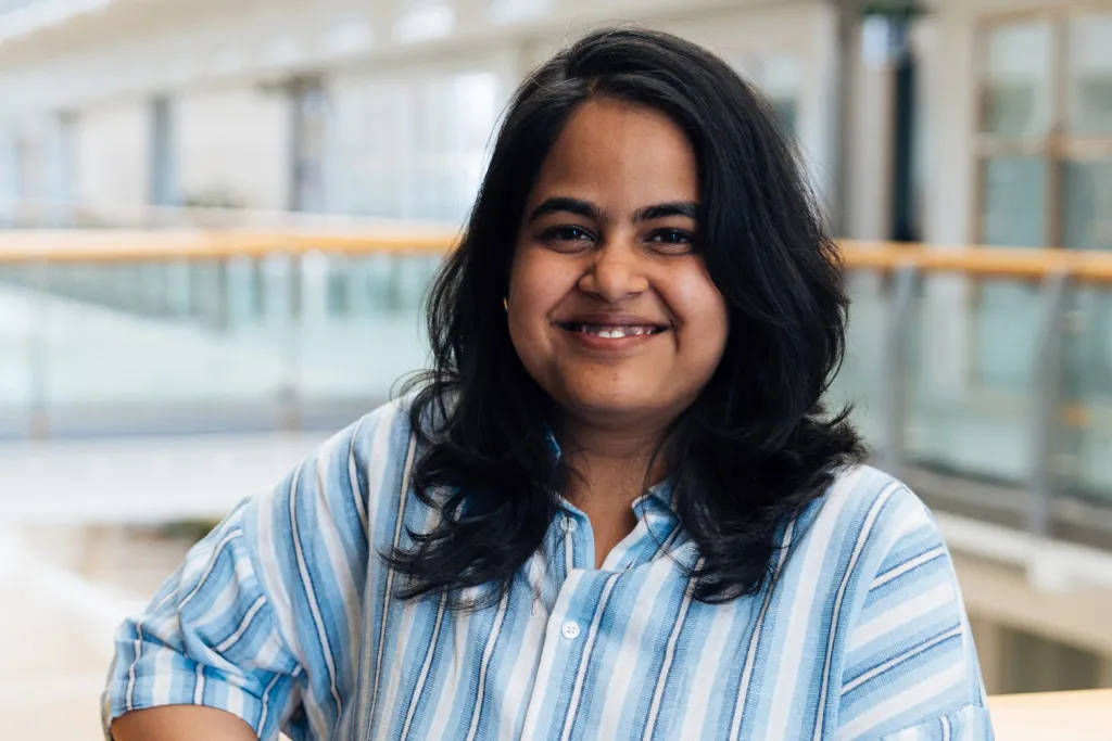 A woman smiles on an upper floor of the office