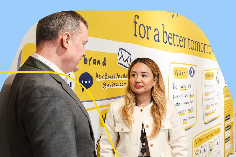 Two finance professionals talking in front of an Aviva mural