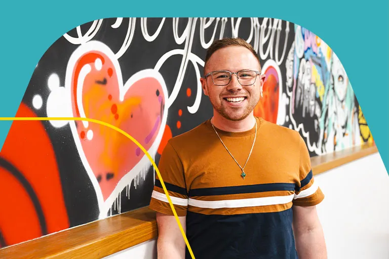 A member of the Aviva comms team standing in front of a mural