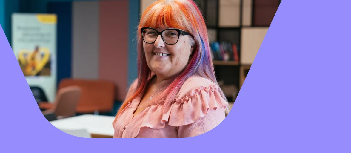 A Customer Services Advisor is smiling in the office