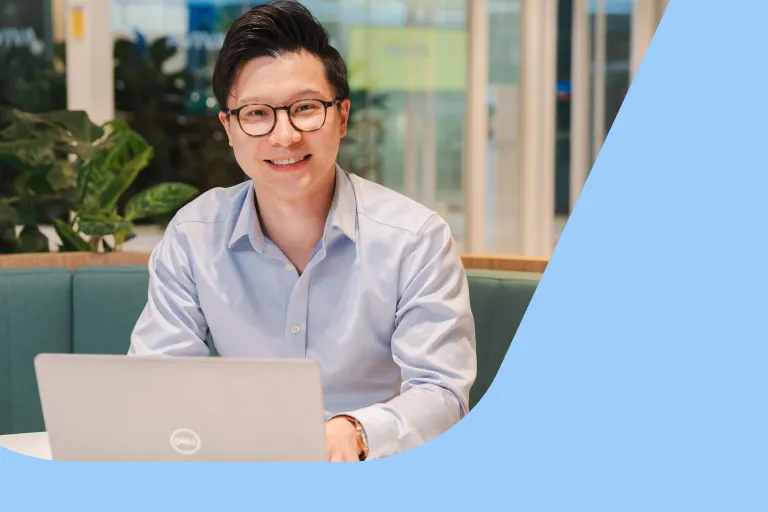 A professional man in glasses is working at a laptop in an Aviva breakout space