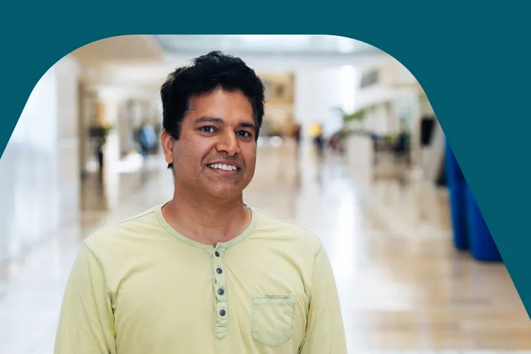 A member of the data team stands smiling in a bright expansive office