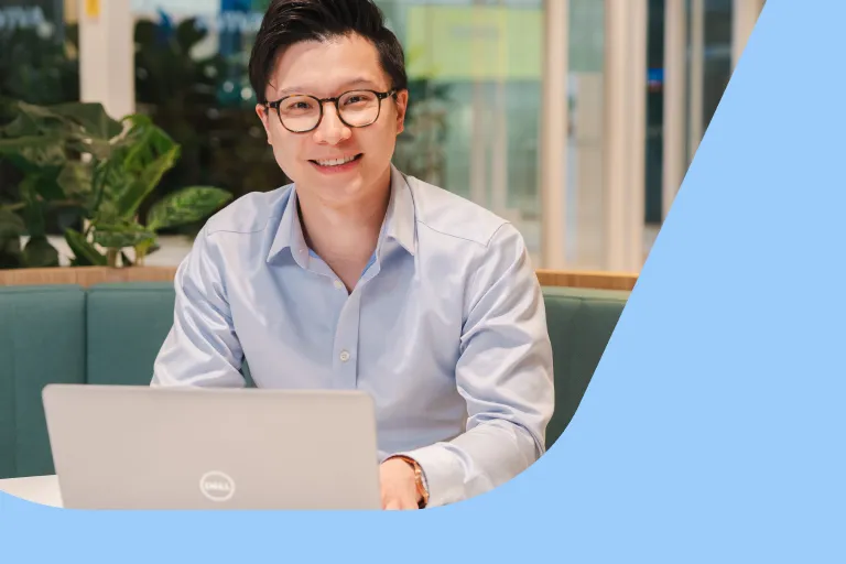 A professional man in glasses is working at a laptop in an Aviva breakout space