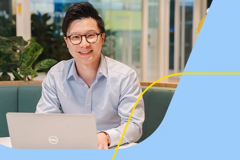 A professional man in glasses is working at a laptop in an Aviva breakout space