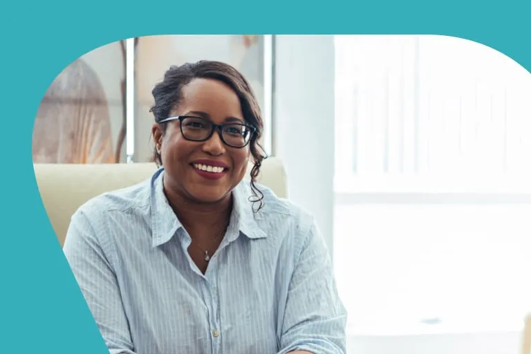 Smiling Black Lady Sat in Front of Bright Window